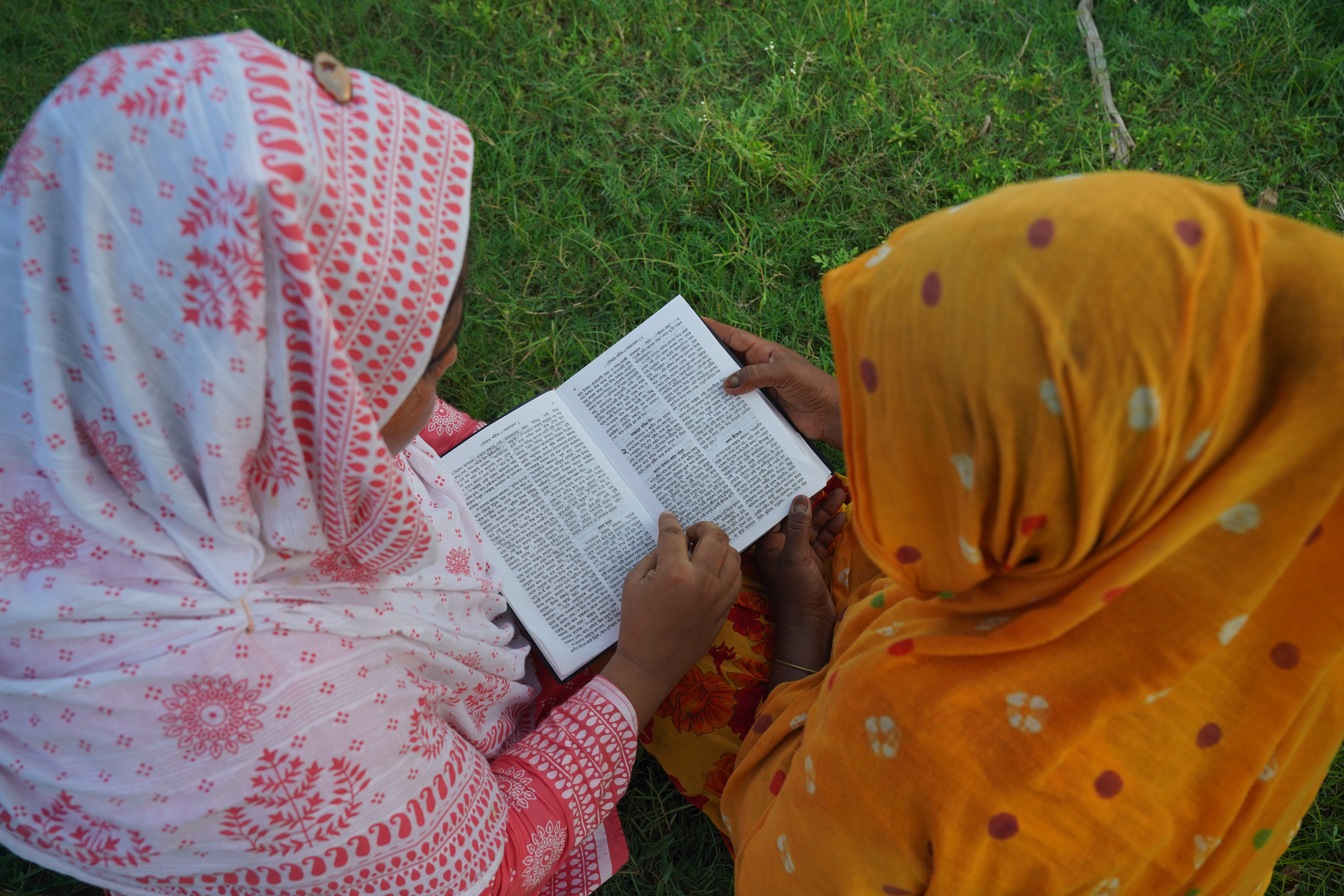 two girls reading a bible