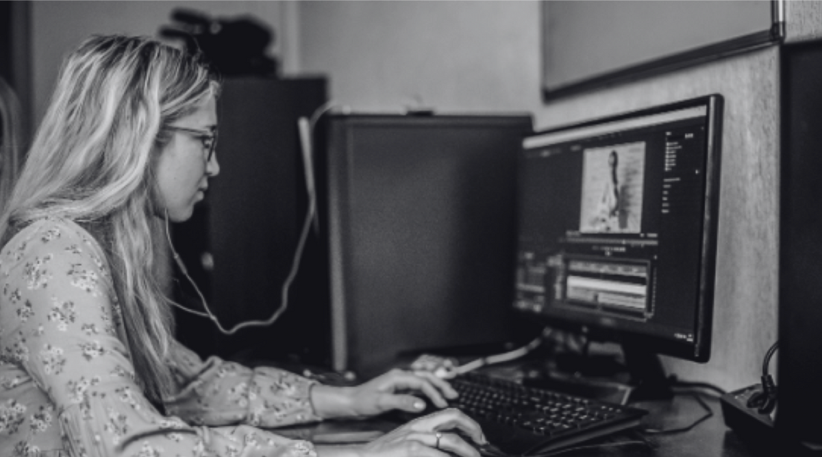 black and white photo of young woman on computer editing