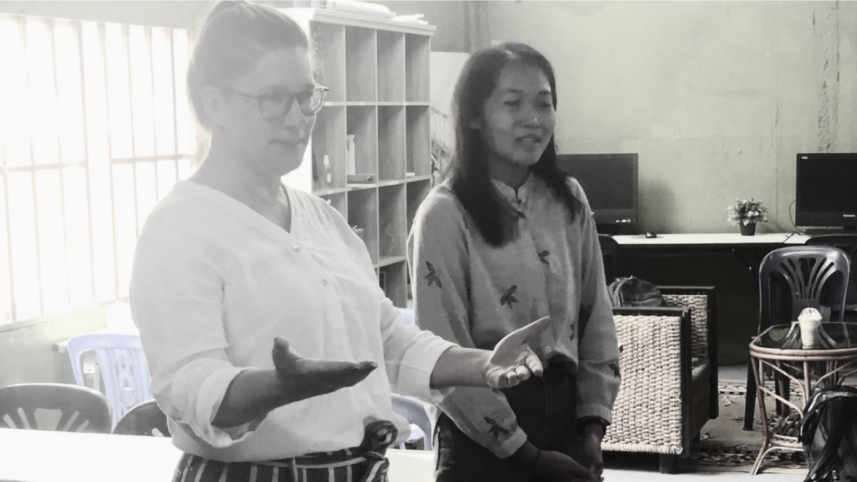 photo of two woman in an office looking in the right direction talking to individuals