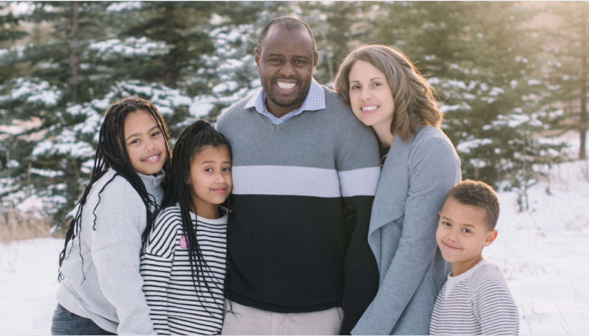 photo of couple and three young children smiling at camera
